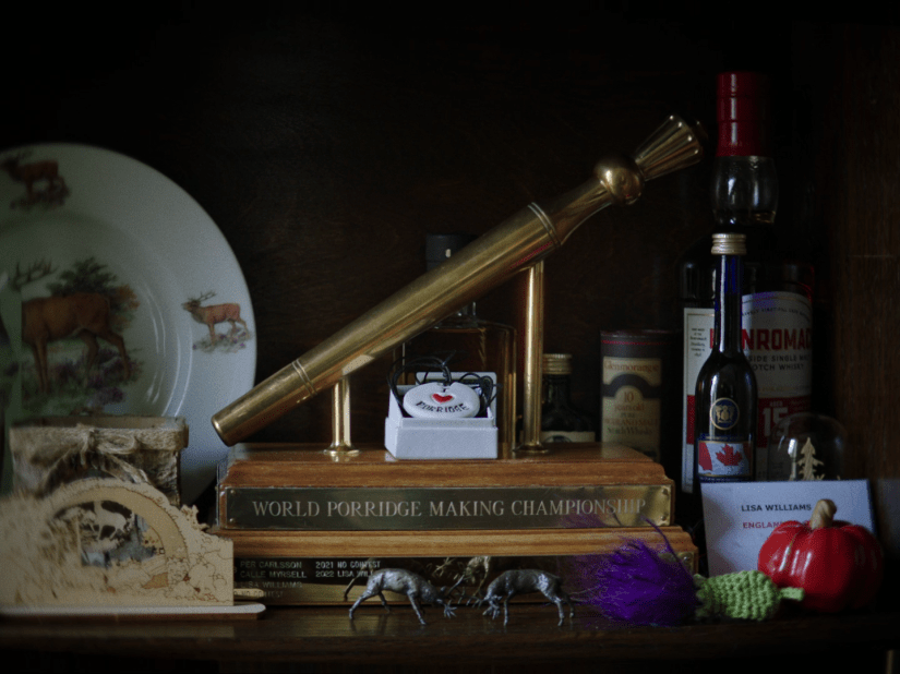 a screenshot of the titular Golden Spurtle, a golden stick mounted on a wooden trophy base, designed to look like the porridge-stirring utensil known as a 'spurtle'